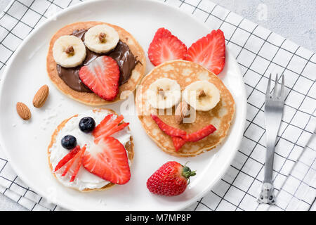 Colazione colorata pasto per bambini. Pancake arte cibo, funny facce di animali realizzato con frutta e cioccolata spalmabile. Concetto di pasto per bambini, bambini dove siamo Foto Stock