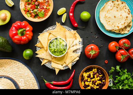 Nachos con guacamole, fagioli, salsa e tortillas. Cibo messicano, tabella vista superiore Foto Stock