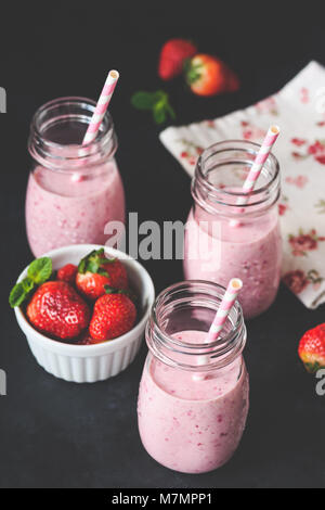 Fragola lampone smoothie in bottiglia jar con cannuccia, il fuoco selettivo, tonica immagine. La detersione, Vegana Vegetariana, estate, detox concept Foto Stock
