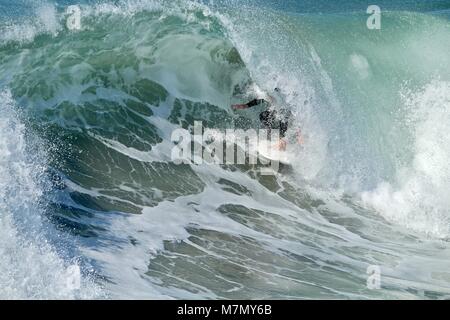 Surfer nella canna di un'onda Foto Stock