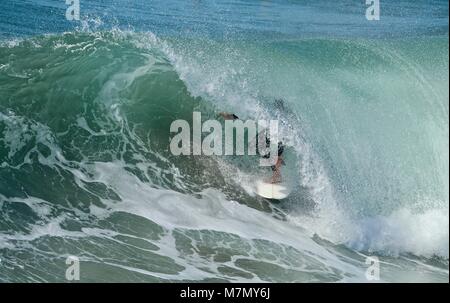 Surfer nella canna di un'onda Foto Stock