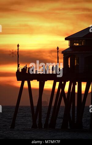 Arancione tramonto dietro il morbo di Huntington Beach Pier Foto Stock