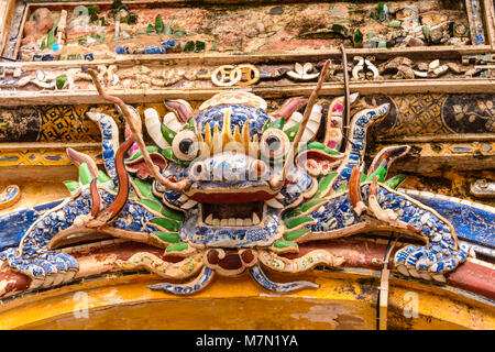 Un ornato di ceramica cinese mosaici di Lion al di sopra di un arco in Hoàng thành (Città Imperiale) una cittadella fortificata costruita nel 1804 in tinta, Vietnam. Foto Stock