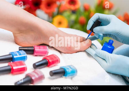 Le mani di un chiodo tecnico la lucidatura toenails di una donna Foto Stock