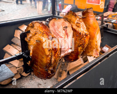 Arrosto di maiale affumicato Prosciutto gambe la grigliatura in via del mercato alimentare a Praga, Repubblica Ceca Foto Stock