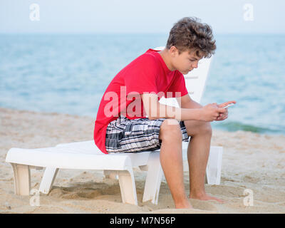 Teen boy sulla spiaggia Foto Stock