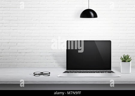 Laptop moderno computer sulla scrivania con schermo vuoto per mockup. Bianco parete di mattoni in background con spazio libero per il testo. Foto Stock