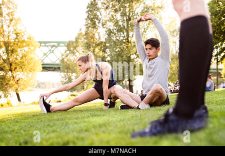 Giovani runner di stretching e di riscaldamento nel parco. Foto Stock