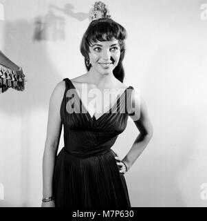 Joan Collins, attrice, 22 anni, raffigurata vestita di nero Seta abito da cocktail, al suo appartamento in Marylebone, London, 10 febbraio 1954. Foto-chiamata dopo dieci mesi di soggiorno a Hollywood. Foto Stock