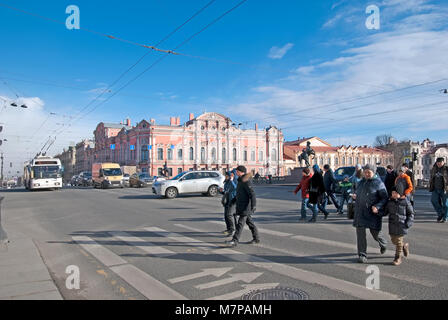 Persone attraversano il Nevsky Avenue vicino al Ponte Anichkov con il domatore dei cavalli da Peter Klodt. Sullo sfondo è Beloselsky-Belozersky Palace Foto Stock