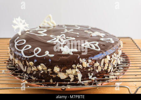 Semi di papavero torta decorata con cioccolato bianco e cioccolato fondente smalto tutto tondo su una tavola di legno Foto Stock