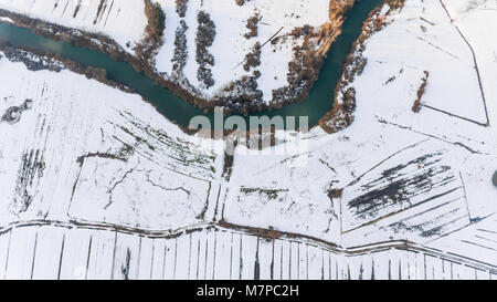 Vista aerea riverbend passando coperta di neve i campi. Foto Stock