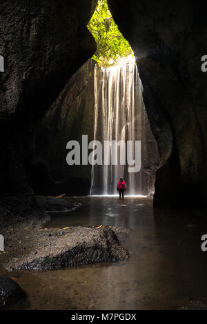 Il meraviglioso sunbeam proveniente dalla parte superiore di un enorme cascata all'interno di una grotta a Bali Foto Stock