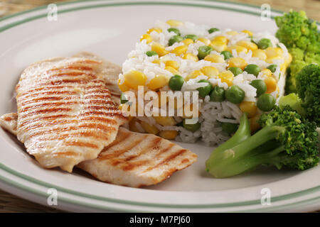 Grigliate di carne di pollo con riso e verdure su un tavolo Foto Stock