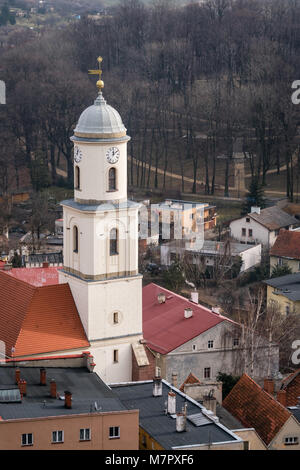 Alta torre dell'orologio del Saint Jadwiga chiesa cattolica nella città di Bolkow nella Bassa Slesia, Polonia, come si vede dalle mura del castello di Bolkow Foto Stock