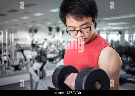 Bel giovane Muscolo uomo che lavora con il manubrio nella sala fitness, esercizio per una buona salute Foto Stock