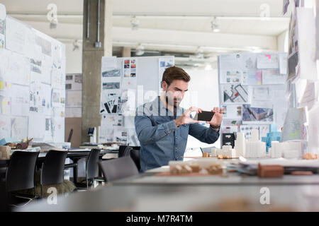 Architetto tenendo la foto del modello in studio Foto Stock