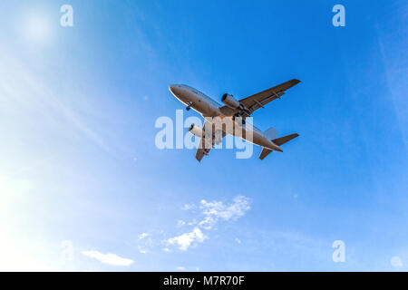 Aeromobile in volo con i passeggeri oltre il cielo blu nella luce del sole splendente paesaggio Foto Stock