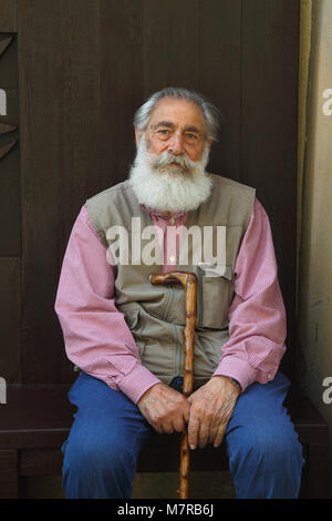 66/5000 uomo italiano con grande barba è seduta su una panchina in Orvieto, Italia Foto Stock