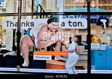 Giovane donna fingeva di snapshot vicino al poster pubblicitario, Chicago Illinois USA Foto Stock