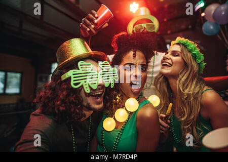 Un gruppo di giovani amici che celebra la festa di San Patrizio a bar. La gente di divertimento presso il bar. Foto Stock