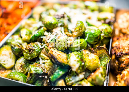 Macro closeup di verde torrefatto cavoletti di Bruxelles Cavoli nel vassoio sul display in buffet e catering, deli, negozio, negozio di generi alimentari freschi di mercato, formaggio Foto Stock