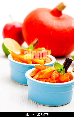 Zucca caramellata e Apple in piccolo vaso su bianco Foto Stock