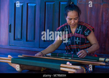 Una donna dalla minoranza Cotu si intreccia con una fascetta telaio in Quang Nam Vietnam Foto Stock