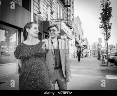 Un ritratto di una giovane incinta in piedi su una strada di Williamsburg, Brooklyn, New York. Foto Stock