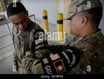 Stati Uniti Air Force Senior Airman Jerick Encarnacion regola personale Sgt. Bryant Brown's Guardia d'onore il manicotto prima di un cambiamento della cerimonia di comando 9 Maggio 2014 a Bagram Airfield, Afghanistan. Encarnacion e Bryant sono parte della 455th Expeditionary disponibilità logistica Squadron e Bagram's Guardia d'onore. Come onore guardie, dimostrano la dedizione, impegno e precisione, nonché esecuzione impeccabile di cerimoniale di Trapani. Encarnacion è distribuito da Eielson Air Force Base in Alaska e un nativo di Vallejo, Calif. Il marrone è distribuito da Scott Air Force Base, Ill. e un nativo di Baltimore, MD Foto Stock