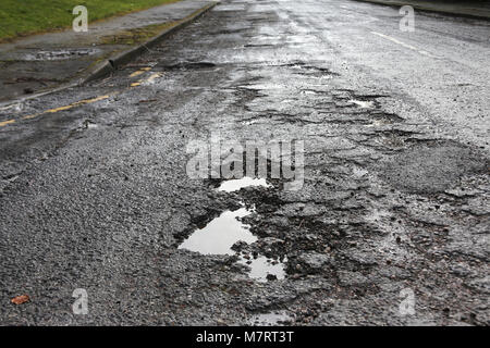 Buca pozza di decadimento su strada asfaltata Foto Stock