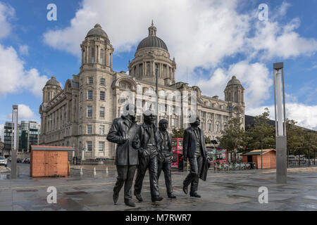 I Beatles Statua in Liverpool con il porto di Liverpool edificio in background - Liverpool, Merseyside, Regno Unito Foto Stock