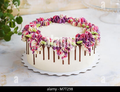 Festosa torta con crema di hydrangea fiori su uno sfondo luminoso Foto Stock