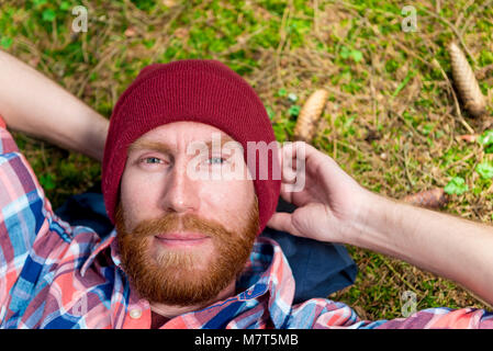 Close-up di un maschio verticale con una barba rossa contro un Forest Lawn sfondo Foto Stock