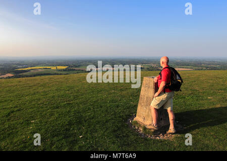 Walker all'ordinanza sondaggio punto Trig, Chanctonbury Ring, South Downs National Park, Sussex, England, Regno Unito Foto Stock