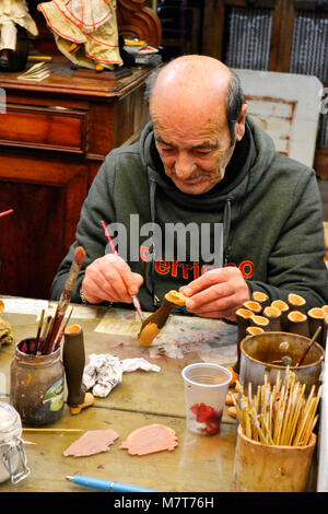 Un artista che lavora sul artigianale di figure per presepi in 'Ferrigno Marco' officina, Via San Gregorio Armeno a Napoli. Foto Stock
