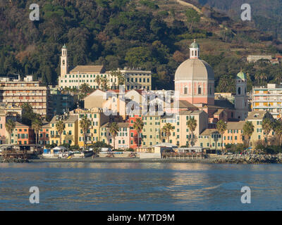 Pegli tipico villaggio in Genova Liguria vista dal mare, colorate case strette, palme e grande chiesa riflettente nel mare Mediterraneo Foto Stock
