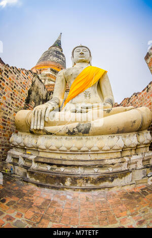 Al di sotto di vista di budha bianco con una stoffa gialla intorno al suo corpo al Sukhothai parco storico della città vecchia di Thailandia antica statua del Buddha al Wat Mahathat in Sukhothai Historical Park,Thailandia Foto Stock