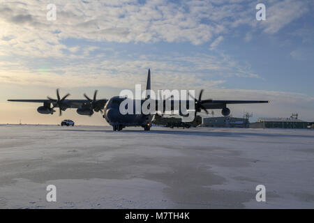 Alaska guardie dall'ala 176preparare per caricare il personale e le attrezzature su un 211th Rescue Squadron HC-130J contro il re II aeromobili a Deadhorse, Alaska, Marzo 7, 2018. Più di 50 aria e l esercito nazionale guardie svolto attività di formazione di diverse centinaia di miglia a nord delle coste dell'Alaska sulla congelati Beaufort Sea. Questo corso di formazione è legata alla Alaska National Guard's Arctic Eagle 2018 e U.S. Marina esercizio di ghiaccio. Un numero del Dipartimento della Difesa degli esercizi permettersi le forze partecipanti la possibilità di operare in un ambiente misto mentre la valutazione della capacità di condurre subito operat Foto Stock