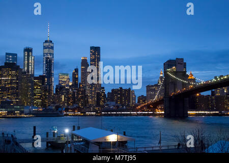 La parte inferiore dello skyline di Manhattan e Brooklyn Bridge come si vede attraverso l'East River da Dumbo Brooklyn di notte Foto Stock