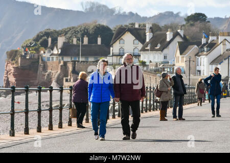 Sidmouth, Devon, Regno Unito. 13 marzo 2018. Regno Unito Meteo. I visitatori e i residenti godendo di una passeggiata lungo il mare presso la città balneare di Sidmouth nel Devon su un caldo e soleggiato pomeriggio di primavera. Credito Foto: Graham Hunt/Alamy Live News. Foto Stock