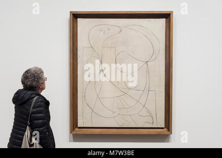 Londra, Regno Unito. Il 13 marzo 2018. Un membro del pubblico viste di un disegno a carboncino " donna con un fiore (Femma un la fleur)" sul display in corrispondenza "Picasso 1932 - amore, fama, tragedia', la Tate Modern la prima mostra personale del lavoro di Pablo Picasso. Più di 100 dipinti, sculture e opere su carta che copre l'anno 1932, un tempo di pivotal di Picasso la vita, sono sul display 8 Marzo al 9 settembre 2018, in una parte dell'anno più popolare in mostra alla Tate Modern. Credito: Stephen Chung / Alamy Live News Foto Stock