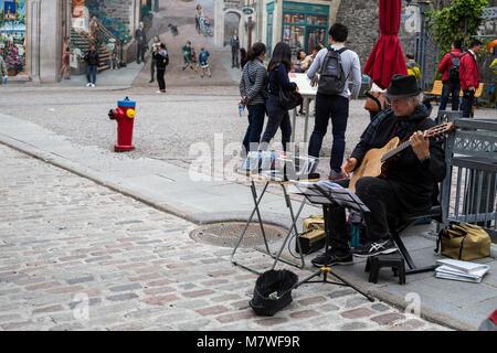 Quebec, Canada. Chitarrista, La Fresque des Quebec in background. Foto Stock