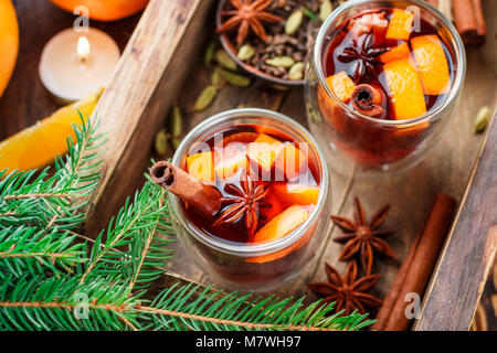 Vin brulé - Natale bevanda calda con Orange, cannella, cardamomo e anice in bicchieri di vetro. Nuovo anno. Messa a fuoco selettiva Foto Stock