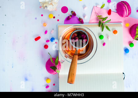 Femminile laico piatta con tè, dolci e libro aperto con le pagine vuote. Partito colorato sfondo con coriandoli. Il concetto di pianificazione con copia spazio. Foto Stock