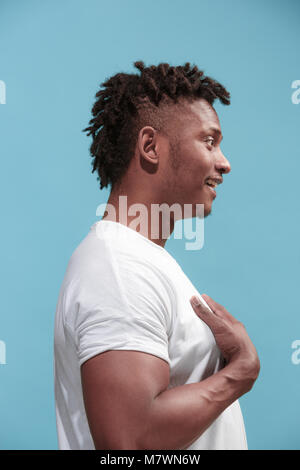 La sorpresa di afro-americana di business man standing e cercando sfondo blu. Vista di profilo. Foto Stock