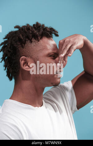 Giovane con disgustato di repulsione di espressione qualcosa, isolato sull'azzurro Foto Stock