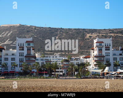 AGADIR, Marocco AFRICA in febbraio 2017: spiaggia in riva al mare a nella città di viaggio con il bianco moderno hotel edifici e palme in bellezza outdoor posti a sedere Foto Stock