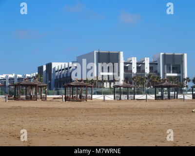 AGADIR, Marocco AFRICA in febbraio 2017: moderno e bianco edificio hotel sulla spiaggia in riva al mare a nella città di viaggio con le palme in bellezza outdoor posti a sedere un Foto Stock