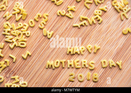 Pasta alfabeto formante il testo Felice Festa della Mamma 2018, Sfondo legno Foto Stock